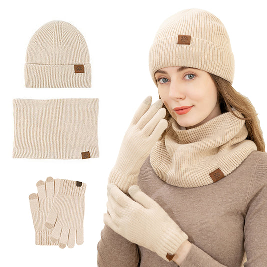 A lady is wearing a hat, scarf, and gloves, with an unfolded diagram of a three-piece set next to her.