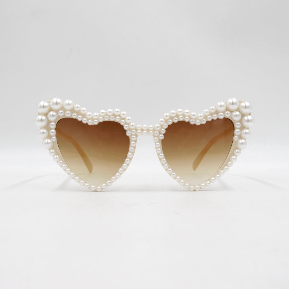 Large frame heart-shaped sunglasses with pearl embellishments, suitable for women to wear during vacations, at the beach, or at birthday parties.