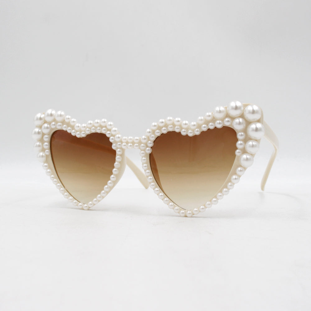 Large frame heart-shaped sunglasses with pearl embellishments, suitable for women to wear during vacations, at the beach, or at birthday parties.
