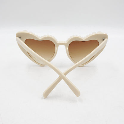 Large frame heart-shaped sunglasses with pearl embellishments, suitable for women to wear during vacations, at the beach, or at birthday parties.