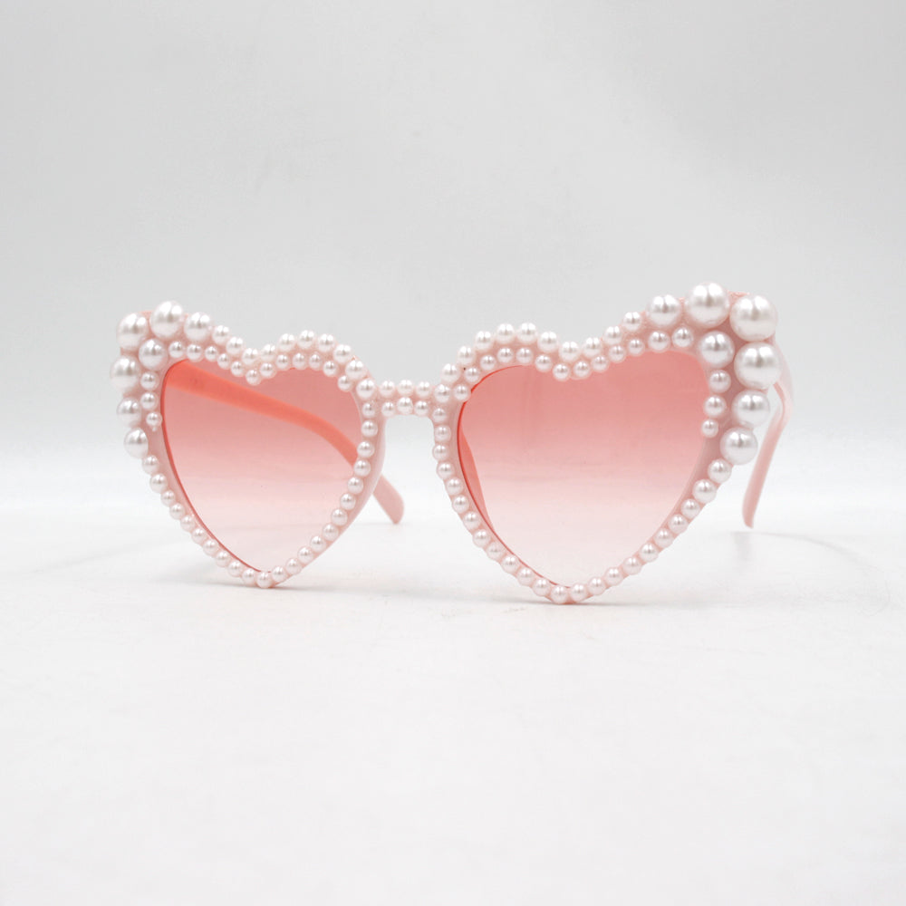 Large frame heart-shaped sunglasses with pearl embellishments, suitable for women to wear during vacations, at the beach, or at birthday parties.